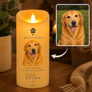 May include: A cylindrical LED candle with a warm yellow glow, featuring a printed portrait of a golden retriever, a paw print icon, and the text "forever loved," "FOREVER MISSED FOREVER IN OUR HEARTS," the name "Max," and the year "2026."