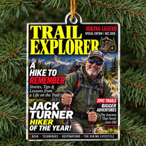 May include: A rectangular acrylic ornament featuring a magazine cover titled Trail Explorer. It shows a smiling hiker with a backpack and trekking poles against a mountain backdrop. Text includes Hiking Legend, A Hike to Remember, and Jack Turner Hiker of the Year, dated December 2026.