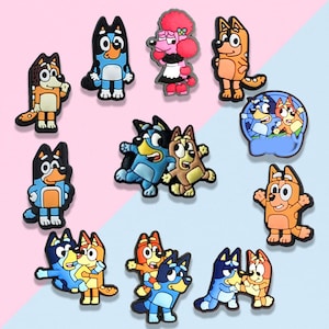 May include: A collection of cartoon character shoe charms in various poses and colors. The charms feature characters in shades of blue, orange, brown, and pink. Some charms depict multiple characters together, while others show individual figures.
