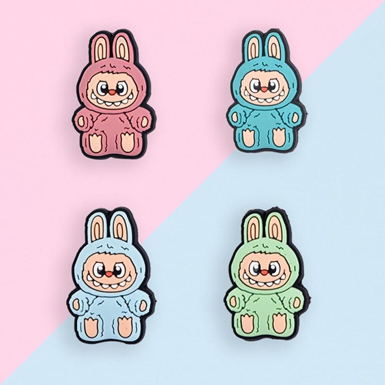 Puede incluir: Cuatro figuras de conejito de dibujos animados de colores en rosa, azul, azul claro y verde. Cada figura tiene una cara sonriente, orejas de conejo y un contorno negro. El fondo est&aacute; dividido diagonalmente, con secciones rosas y azul claro.