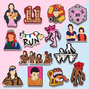 May include: A collection of colorful shoe charms featuring characters and symbols from the popular science fiction series. The charms include characters, a dice, the number 11, and the word "RUN".