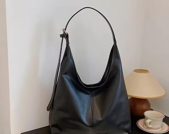 Borsa a tracolla nera con spallacci regolabili, ideale per l'università.