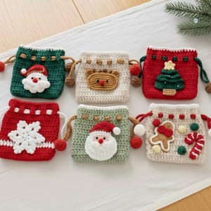 May include: Six handmade crochet drawstring bags with Christmas designs. Each bag features a different festive motif, including Santa Claus, a reindeer, a Christmas tree, a snowflake, and gingerbread men, in red, green, and cream colours.