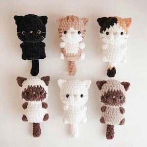 May include: Six handmade crochet cat plushies in various colors: black, tan and white, calico, Siamese, and white. Each plush has a cute cat face, small arms, and a tail. These soft toys are perfect for cat lovers.