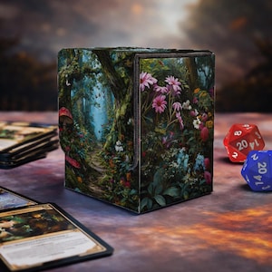 May include: A square card storage box with a forest scene design. The box features a path leading into a lush forest with flowers and mushrooms. Two dice are visible, one red and one blue, along with several cards.