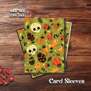 Può includere: Custodie per carte con sfondo verde e motivo ripetuto di coccinelle arancioni, teschi e foglie. Le custodie misurano 66 mm per 91 mm. Il testo "Card Sleeves" è visualizzato in bianco.