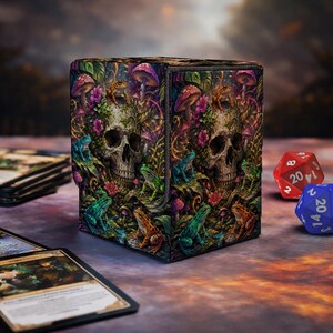 May include: A rectangular deck box featuring a vibrant, detailed illustration of a human skull surrounded by colourful frogs, purple mushrooms, and green foliage. The artwork covers the exterior surfaces, showcasing a dark, naturalistic theme.