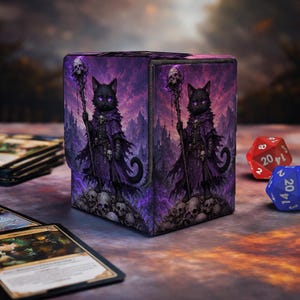 May include: A rectangular deck box featuring a black cat character wearing a purple cloak and holding a staff topped with a skull. The background shows a purple landscape with mountains and a pile of skulls. The box is decorated with matching artwork.