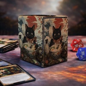 May include: A rectangular deck box featuring a black cat illustration eating ramen, set against a background of a red sun, cherry blossoms, and a large wave. The design includes traditional pottery and food items, with a red 20-sided die nearby.