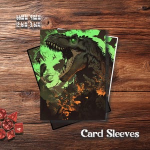Puede incluir: Fundas para cartas con una ilustración de un Tyrannosaurus Rex en verde y naranja. Las fundas miden 66 mm x 91 mm. El texto "Card Sleeves" se muestra en blanco. Dados rojos visibles en la esquina inferior izquierda.