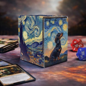 Può includere: Scatola porta carte con "Notte stellata" di Van Gogh e un bassotto. La scatola è blu, gialla e nera. Dadi rossi e blu visibili. L'interno è nero.