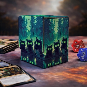 May include: A rectangular deck box featuring a vibrant green forest scene with several black cats with glowing green eyes sitting on a dock, each holding a fishing rod. The box has a textured surface and a lid that folds over the front panel.