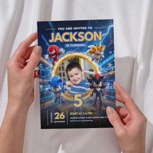 Pode incluir: Um cartão de convite de aniversário retangular com personagens de Sonic the Hedgehog, incluindo Knuckles, Tails, Sonic e Shadow, ao redor de uma moldura central. O texto diz YOU ARE INVITED TO JACKSON IS TURNING 5 em fundo azul.