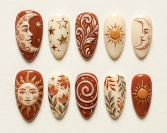 May include: A set of ten almond-shaped press-on nails featuring a celestial and botanical theme. The designs include raised 3D motifs of suns, crescent moons with faces, stars, swirling patterns, and floral elements in shades of terracotta, cream, and brown.