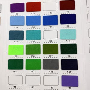 May include: A colour chart displaying rectangular felt swatches in a range of hues, such as purple, red, blue, green, and grey. Each swatch is numbered. The chart is designed for colour selection and comparison.