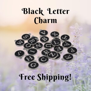May include: A collection of black letter charms with silver-colored borders. Each charm features a different letter in white. The words "Black Letter Charm" are at the top of the image.