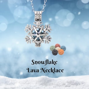 Puede incluir: Un collar con colgante de copo de nieve plateado con una piedra azul en el centro. El collar se muestra con una colección de pequeñas cuentas de lava de colores. El texto "Snowflake Lava Necklace" está debajo.