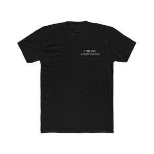 May include: Black t-shirt with the text "FOILERS ANONYMOUS" printed in white. The short-sleeved shirt is made of a soft material and has a crew neck. The text is centered on the chest.
