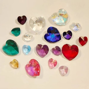 May include: Assortment of heart-shaped crystal beads in various colors, including red, blue, green, purple, pink, and clear. The beads are perfect for jewelry making, crafting, and home decor.
