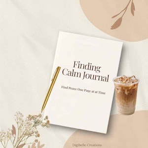 May include: A white journal with the title Finding Calm Journal and the subtitle Find Peace One Page at at Time printed in dark brown text. A gold pen rests on the cover next to a plastic cup of iced coffee and a sprig of dried flowers.