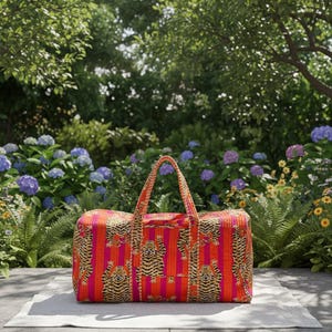 May include: A rectangular duffel bag featuring a vibrant pattern of orange and pink vertical stripes overlaid with repeating tiger illustrations. The bag includes two matching fabric handles and a zippered top closure for secure storage.