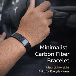 May include: A minimalist carbon fiber bracelet. The black bracelet is lightweight and designed for everyday wear. The bracelet is shown on a person's wrist.