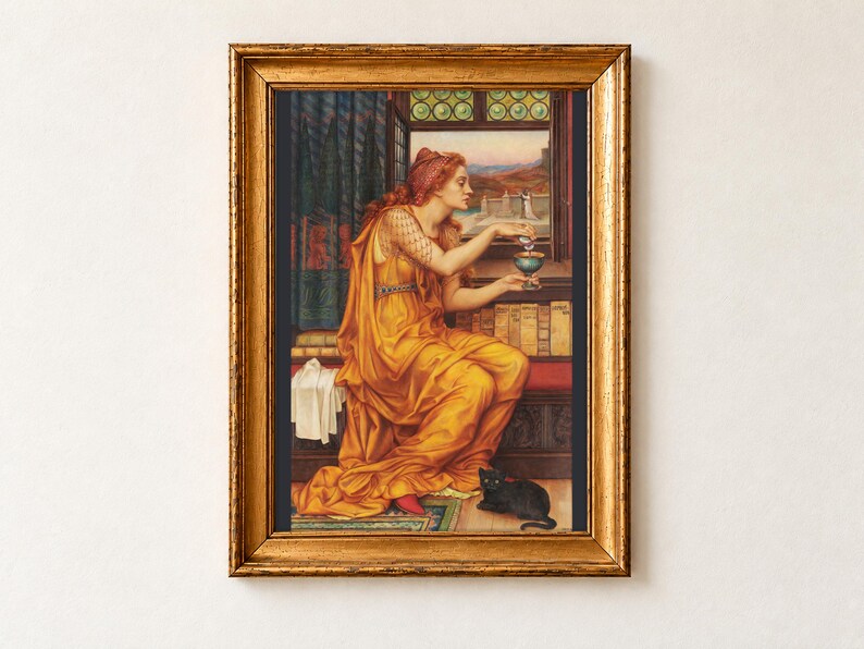 The Love Potion by Evelyn De Morgan, 1903, as a framed print in an antique gold frame on a cream wall. A red-haired sorceress in a golden robe pours a potion into a goblet beside shelves of old books, a black cat with green eyes at her feet.