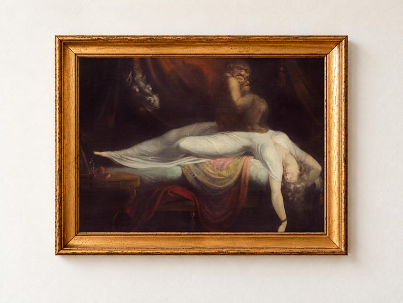 The Nightmare by Henry Fuseli, 1781, as a framed print in an antique gold frame on a cream wall. A sleeping woman in a white gown lies across a bed while a demon crouches on her chest and a wild-eyed horse looks in through red curtains.
