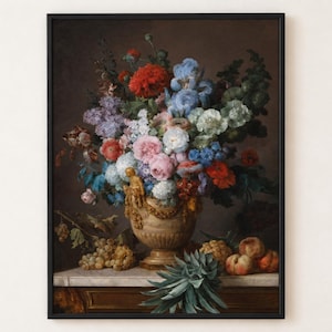 A framed oil painting depicting a large floral arrangement in a decorative beige urn, featuring red, blue, pink, and white flowers. Grapes, peaches, and a pineapple are arranged on a marble surface below the urn.