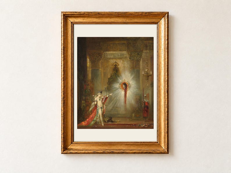 The Apparition by Gustave Moreau, 1876, as a framed print with a cream border in an antique gold frame on a cream wall. Salome points towards the glowing, haloed head of John the Baptist as it appears in the air before her inside a richly decorated palace.