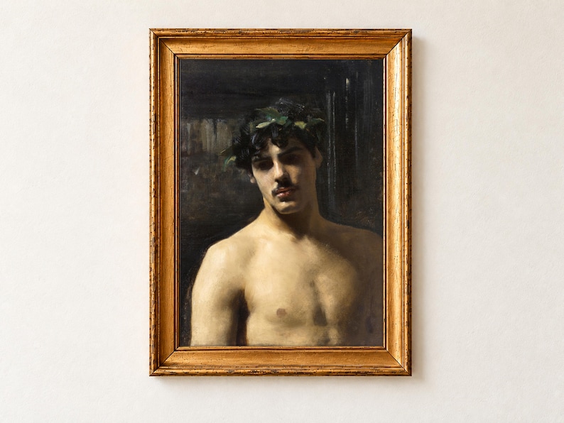 Man Wearing Laurels by John Singer Sargent as a framed print in an antique gold frame on a cream wall. A bare-shouldered young man with dark curls and a moustache wears a crown of green laurel leaves, his face half in shadow against a dark background.