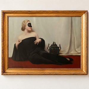 The Mask by Bruno Croatto as a framed print in an antique gold frame on a cream wall. A blonde woman in a black wrap and black eye mask reclines on a red floor beside a gilded incense burner, against a white silk curtain.