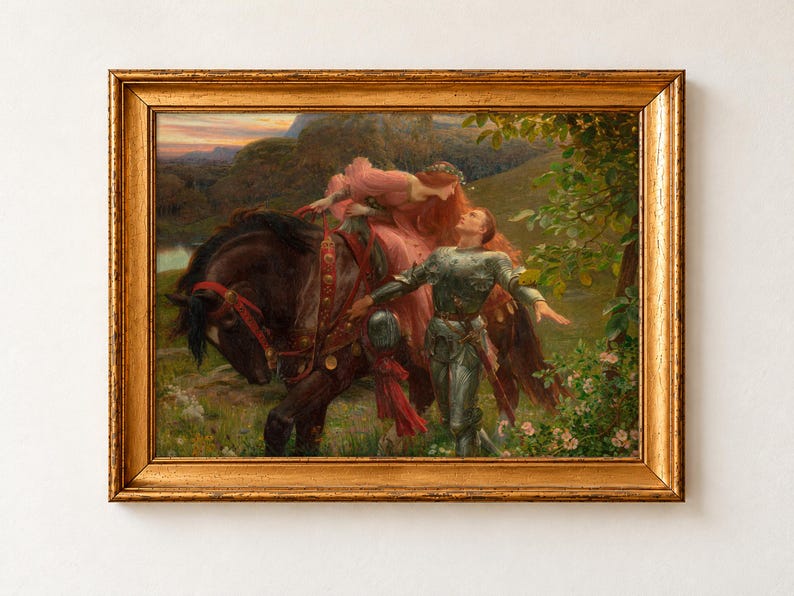 La Belle Dame sans Merci by Frank Dicksee, about 1902, as a framed print in an antique gold frame on a cream wall. A red-haired woman in a pink gown leans down from a dark horse towards a knight in armour who walks beside her through a flowering meadow.