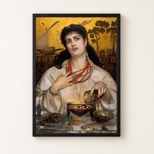 Medea by Frederick Sandys, 1868, as a framed print in a black frame on a cream wall. A dark-haired woman in a white robe and coral necklaces pours a potion into a glowing brazier, with the ship Argo and the Golden Fleece painted on a gold background behind her.