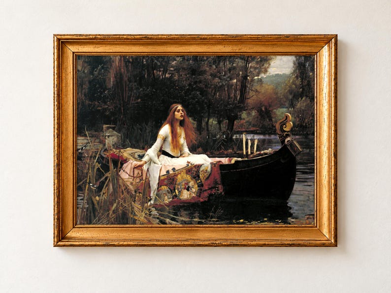 The Lady of Shalott by John William Waterhouse, 1888, as a framed print in an antique gold frame on a cream wall. A red-haired woman in a white gown sits in a wooden boat on a reed-lined river, her tapestry trailing in the water and three candles at the prow.