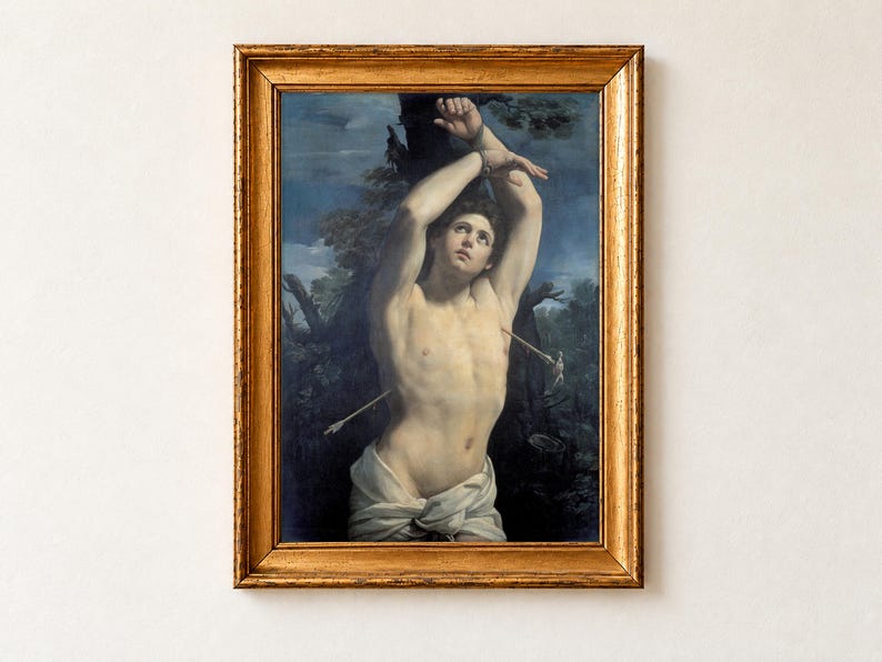 Saint Sebastian by Guido Reni, 1615, as a framed print in an antique gold frame on a cream wall. The young martyr, his arms bound above his head, gazes heavenward with an arrow in his side, his pale figure lit against a dark blue sky.