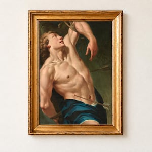 Saint Sebastian, North Italian School, c. 1700, as a framed print in an antique gold frame. A young man with his arms bound above his head looks upward, an arrow through his waist and deep blue drapery at his hips, against a dark green ground.