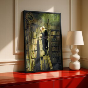 Carl Spitzweg artwork in a black frame above a red dresser with a lamp