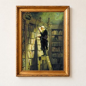 The Bookworm by Carl Spitzweg, c. 1850, as a framed print in an antique gold frame. An elderly scholar in a black tailcoat stands on a wooden library ladder, reading a book held close to his face, with a red book under his arm, below a gilded Metaphysik plaque and a green painted ceiling.