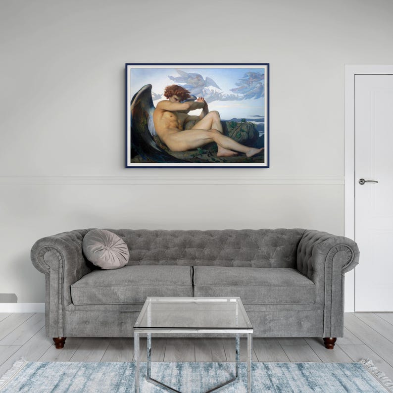 May include: A framed wall art print featuring a painting of a seated figure with large dark wings and reddish hair, positioned against a mountainous landscape with a cloudy sky. The artwork is displayed in a dark blue frame on a wall.