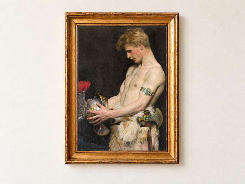 Germanic Warrior with Helmet by Osmar Schindler, 1902, as a framed print in an antique gold frame on a cream wall. A fair-haired young warrior, bare-chested in a fur wrap with a turquoise armband, looks down at the silver helmet with a red plume he holds in both hands, against a dark background.