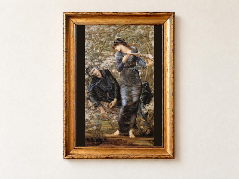 The Beguiling of Merlin by Edward Burne-Jones as a framed print in an antique gold frame on a cream wall. Nimue, in a blue gown with serpents in her hair, reads from a spell book as Merlin slumps entranced in a flowering hawthorn tree.