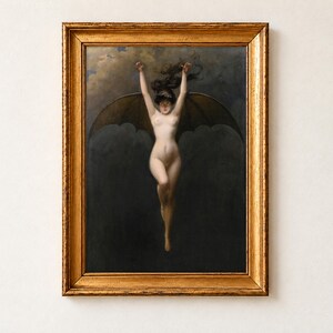 The Bat Woman by Albert Joseph Penot, about 1890, as a framed print in an antique gold frame on a cream wall. A pale woman with great dark bat wings hangs with her arms raised above her head against a smoky night sky.