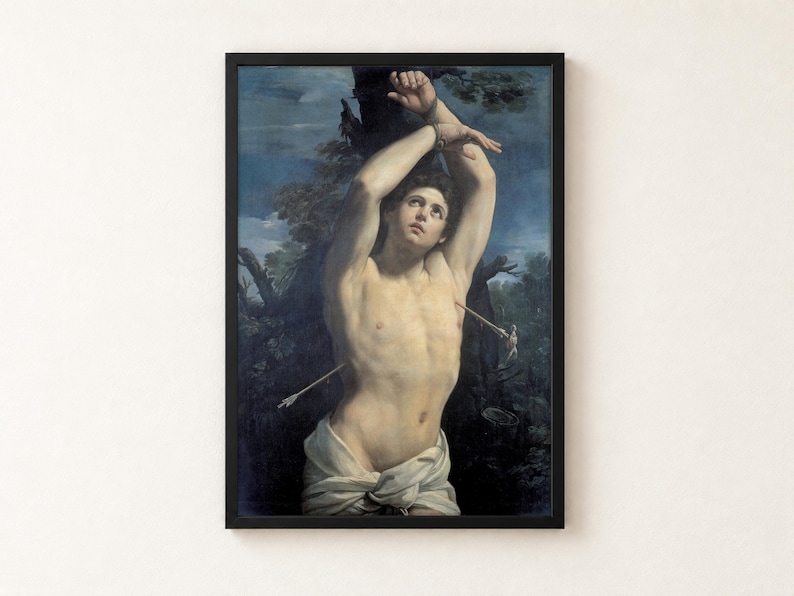 Saint Sebastian by Guido Reni, about 1615, as a framed print in a black frame on a cream wall. A young man with his wrists bound above his head to a tree looks up to the sky, pierced by two arrows, a white cloth at his hips, against blue sky and dark leaves.
