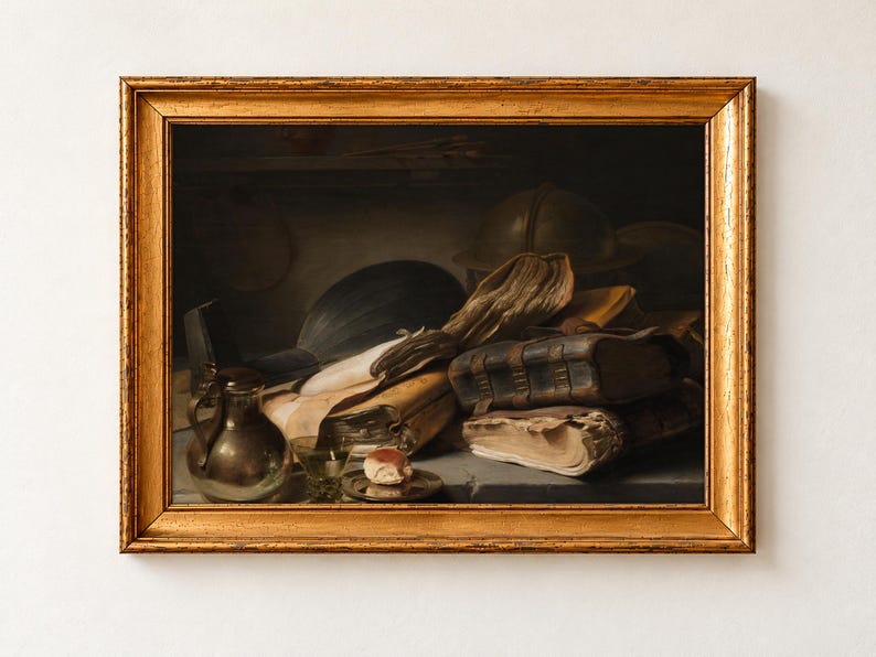 Still Life with Books by Jan Lievens, about 1628 to 1632, as a framed print in an antique gold frame on a cream wall. A heap of worn leather books and loose papers lies beside a lute, a globe, a pewter jug and a glass on a dim table.
