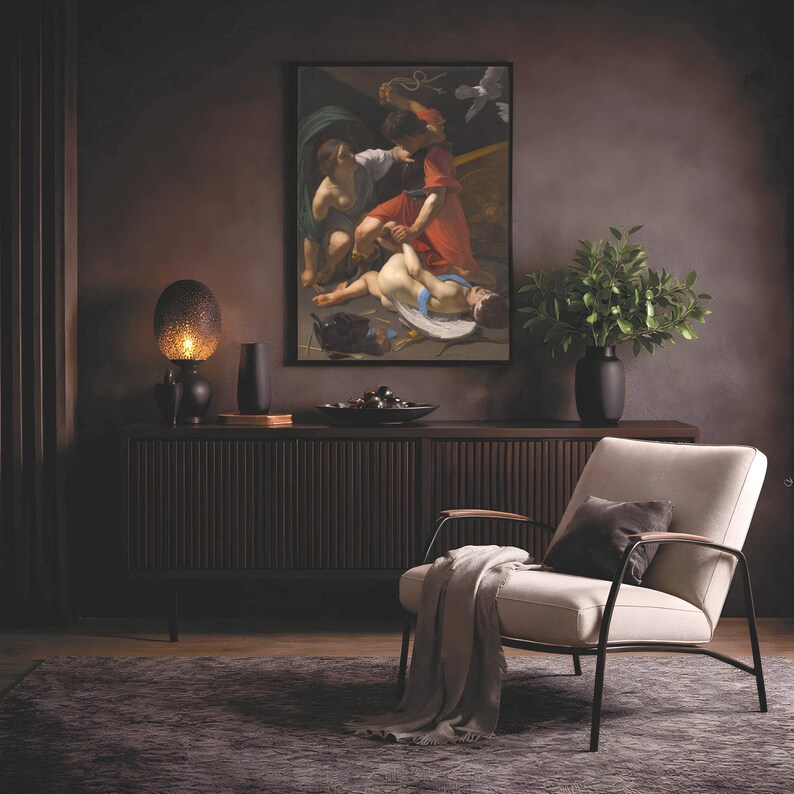 May include: A framed oil painting depicting a classical scene with figures in red and white robes, displayed above a dark brown slatted sideboard. A textured lamp, a black vase, and a bowl sit on the sideboard next to a green potted plant.