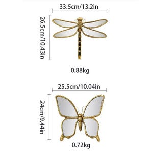May include: Two decorative wall mirrors, one dragonfly and one butterfly. The dragonfly mirror is 13.2 inches wide and 10.43 inches tall. The butterfly mirror is 10.04 inches wide and 9.44 inches tall. Both mirrors have gold frames and reflective surfaces.