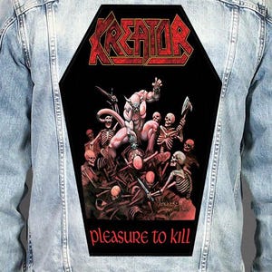 May include: A light blue denim jacket featuring a large, coffin-shaped back patch. The patch displays the red text KREATOR above a graphic illustration of a horned creature surrounded by skeletons holding weapons, with the text pleasure to kill below.