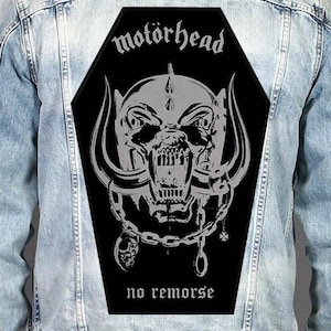 May include: A light blue denim jacket featuring a large, black, coffin-shaped back patch. The patch displays a grey graphic of the Motörhead Snaggletooth mascot, the text "motörhead" at the top, and the text "no remorse" at the bottom.
