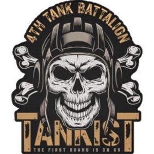 Op de afbeelding: Een zwart en bruin patch met een gedetailleerde schedel met een tankhelm. De tekst "4TH TANK BATTALION" staat boven de schedel, met "TANKIST" eronder. De zin "THE FIRST ROUND IS ON US" staat onderaan.